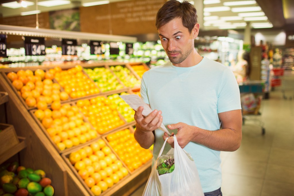 An amazed shopper checking their grocery bill.